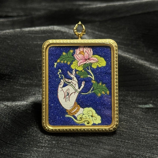 Hand-painted White Tara sacred hand mini thangka pendant showing a graceful Tara hand holding a lotus flower against a deep blue background in a gold pendant frame.