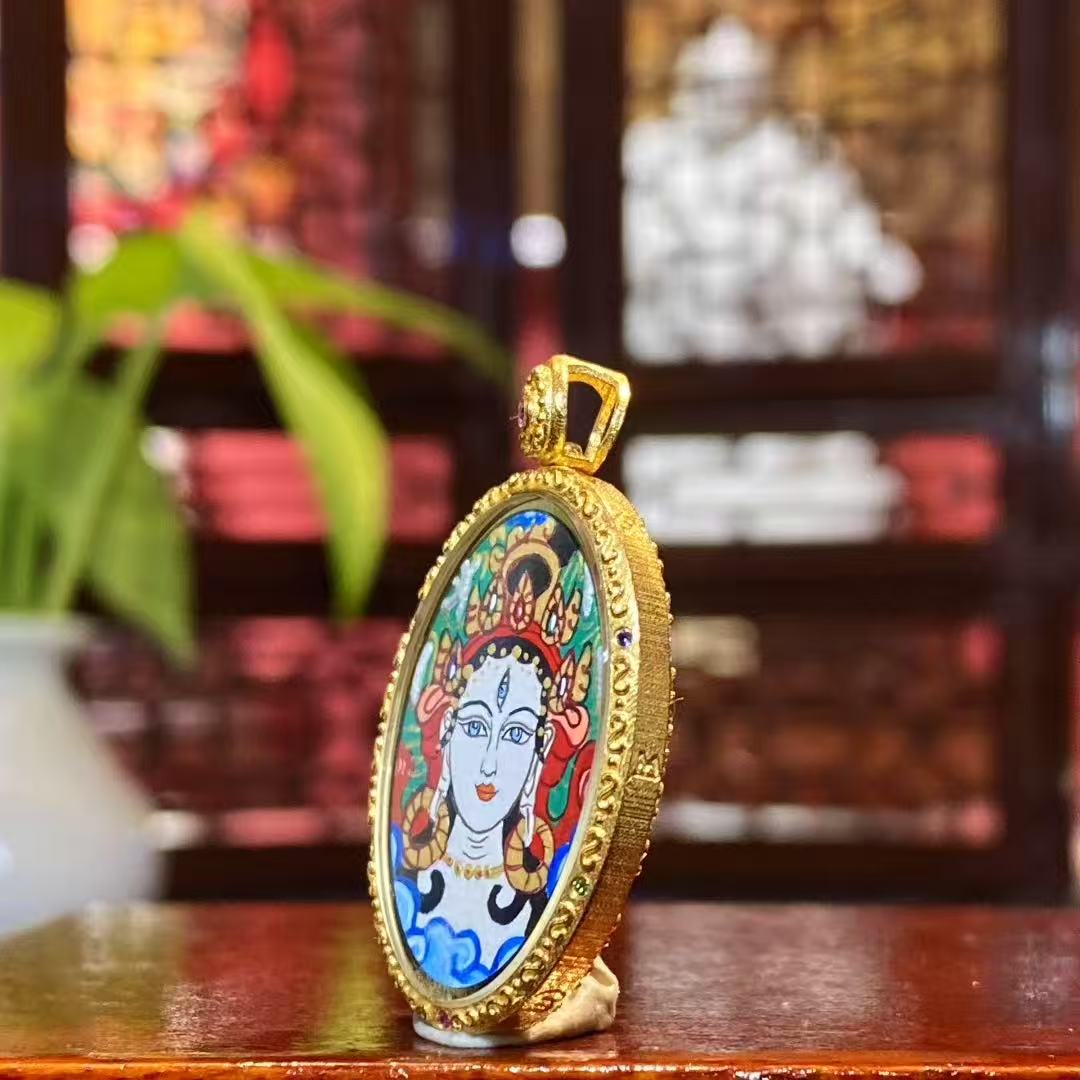 Side view of White Tara Thangka pendant showing 18K gold Gawu box and double sapphire crystal scratch-resistant lenses