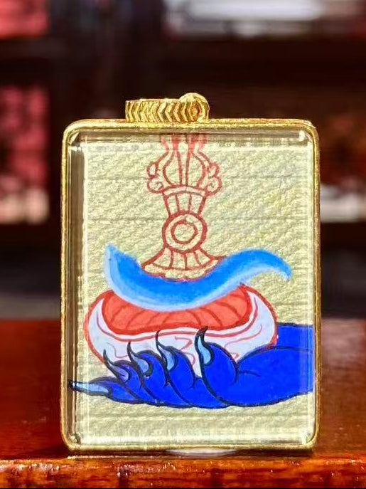 Back view of double-sided thangka pendant featuring a wrathful protector holding skull cup and chopper, symbolizing removal of ignorance and negative forces