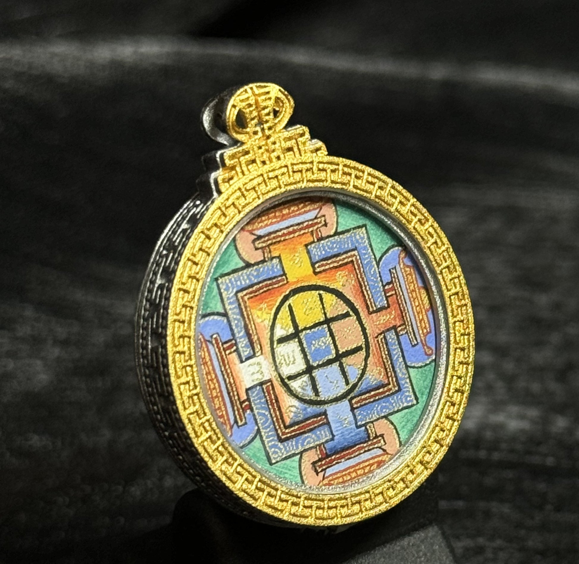 Yamantaka Mandala mini thangka pendant displayed upright with colorful hand-painted mandala pattern inside a circular gold decorative frame.