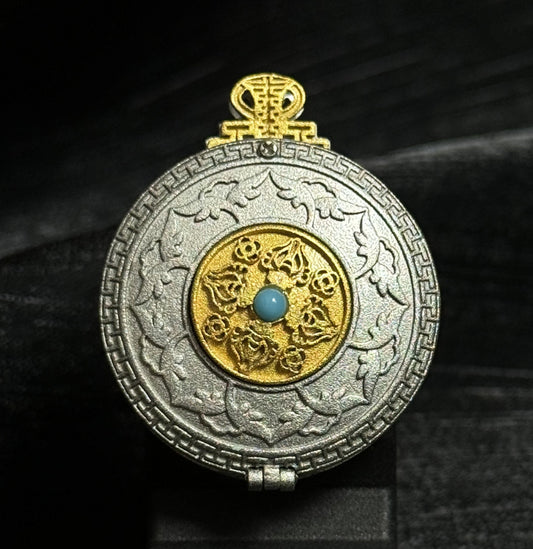 Front view of a Yamantaka Mandala mini thangka pendant with hand-painted mandala artwork inside a circular gold-toned and silver-toned pendant frame.