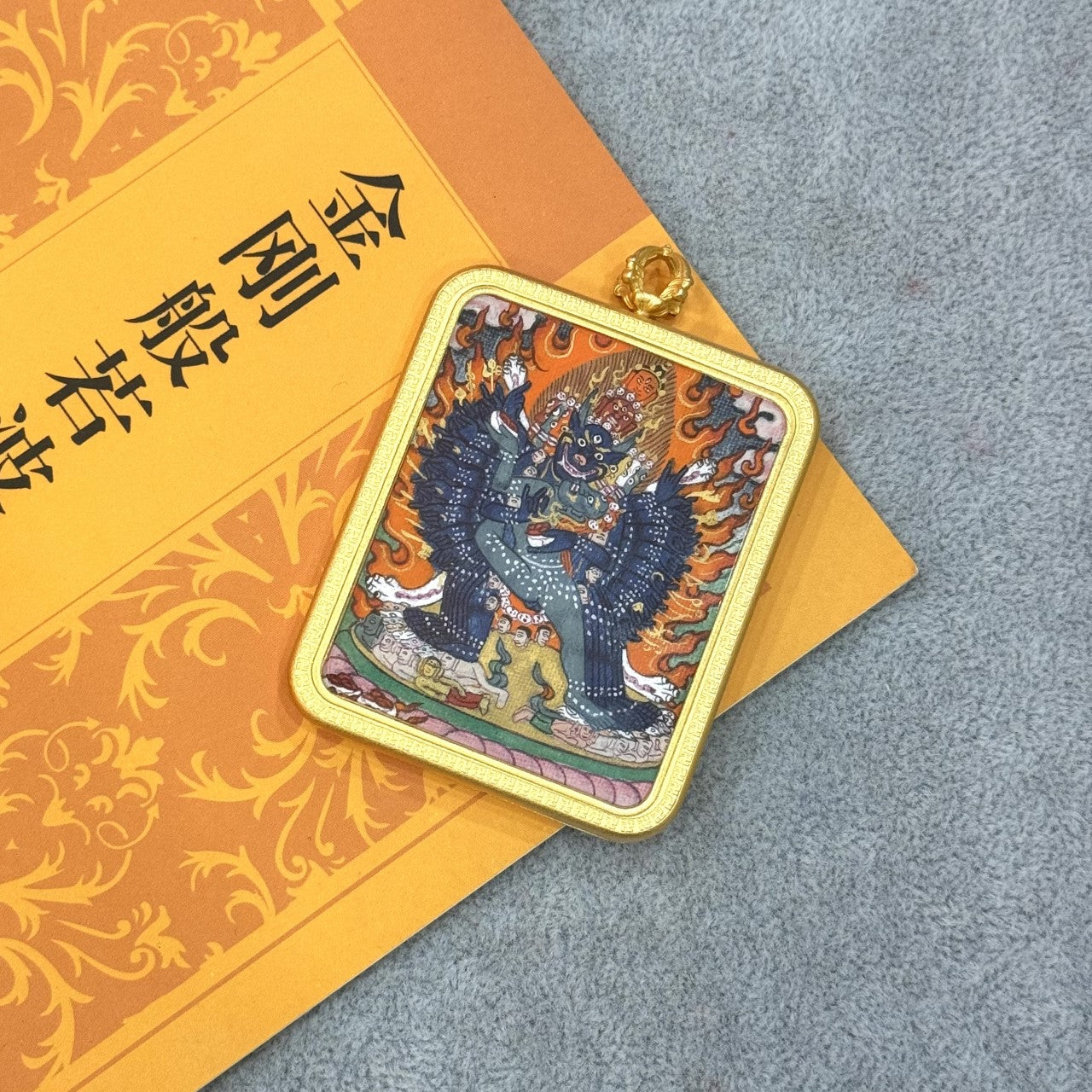 Front view of Yamantaka mini thangka pendant, hand-painted with mineral pigments, featuring wrathful deity iconography and housed in a traditional copper case.