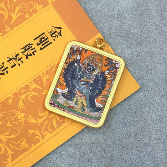 Front view of Yamantaka mini thangka pendant, hand-painted with mineral pigments, featuring wrathful deity iconography and housed in a traditional copper case.