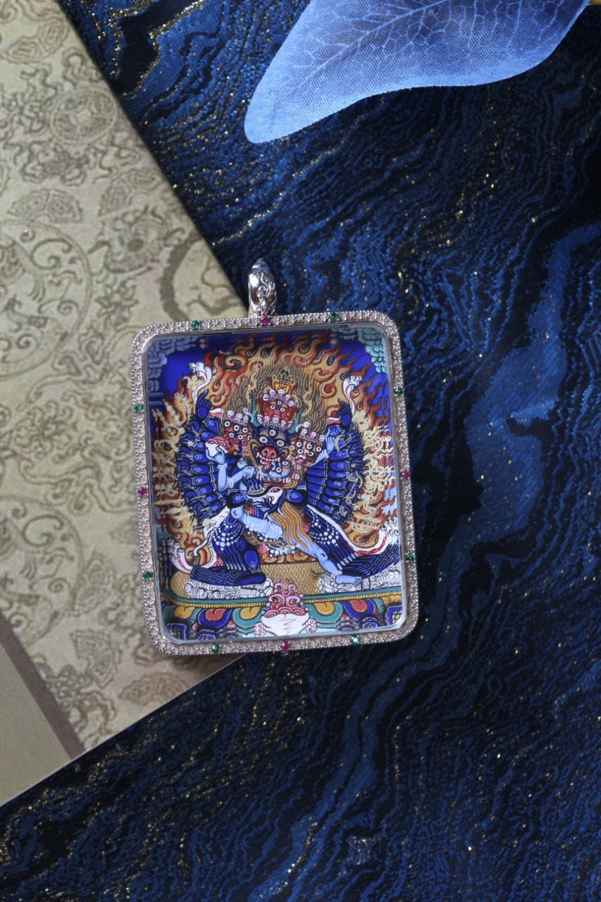 Yamantaka mini thangka pendant displayed in a lifestyle setting as a portable Tibetan Buddhist art piece, suitable for collectors and for use in a meditation space, travel altar, or personal shrine.