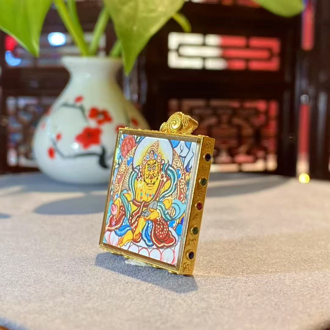 Detail view of 18K gold Yellow Jambhala Gawu pendant with sapphire crystal glass and Rebgong hand-painted artwork