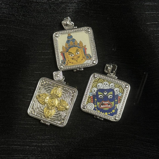 Full set view of double-sided mini thangka gawu pendant showing Yellow Jambhala face panel, wrathful Mahakala face panel with skull crown, and the back plate with gold-tone double vajra on a textured silver case