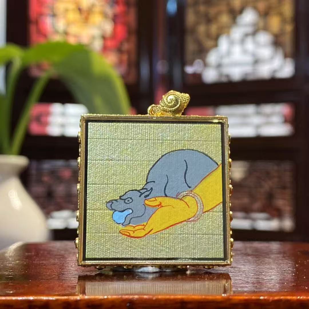 Back view of a double-sided hand-painted Yellow Jambhala mini Thangka pendant, reinforcing the continuous flow of wealth symbolism