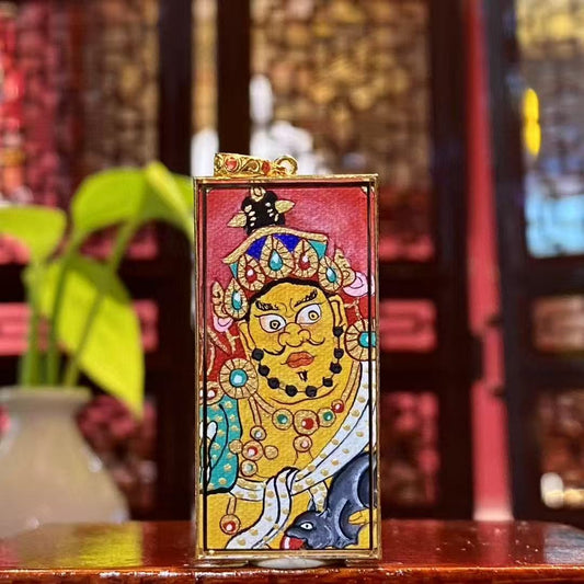 Front view of Yellow Jambhala Gau Thangka pendant in 18K gold, hand-painted in Rebgong style with mineral pigments in an elongated Wushi plate design