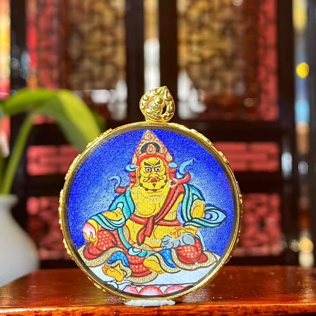 Front view of Yellow Jambhala Gau Thangka pendant in 18K gold, hand-painted in traditional Rebgong style with mineral pigments, circular 32 mm design