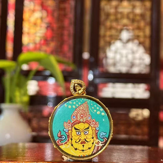 Front view of Yellow Jambhala Gau Thangka pendant in 18K gold, hand-painted in traditional Rebgong style with mineral pigments, circular 32 mm design