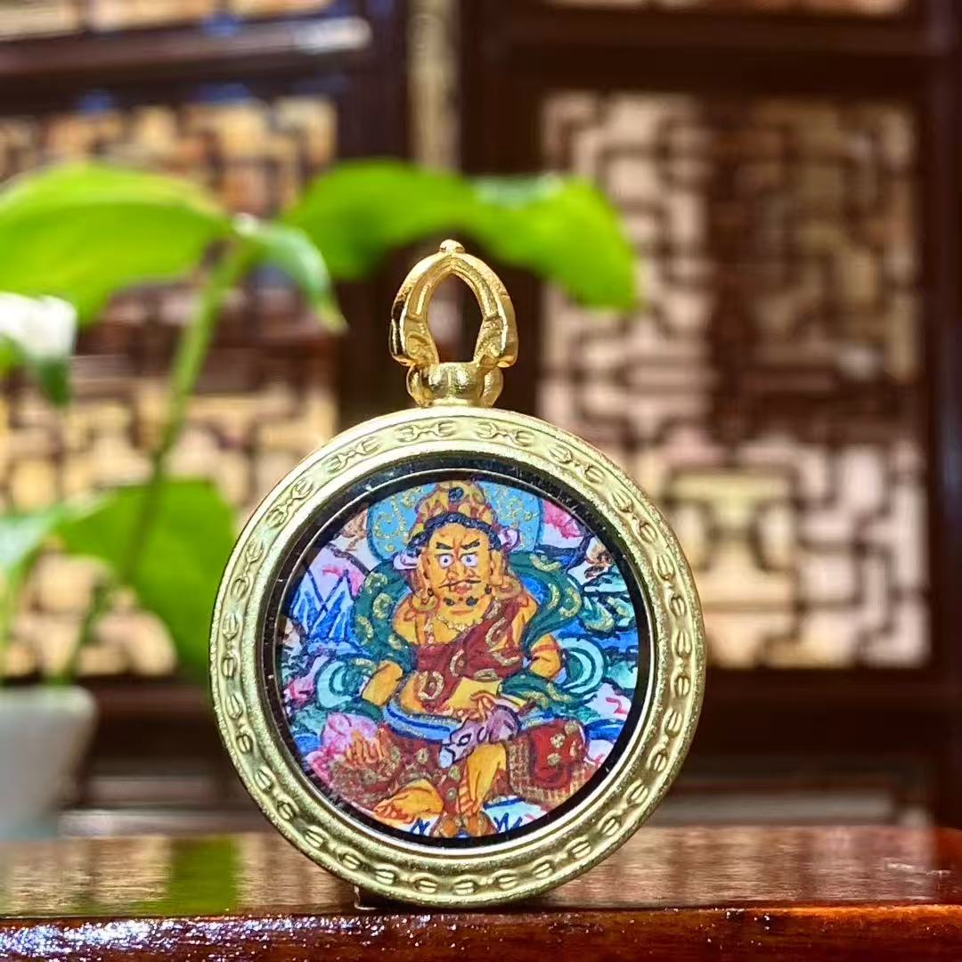 Front view of hand-painted Yellow Jambhala Thangka set in a titanium steel Tibetan Gawu pendant, God of Wealth with jewel-spitting mongoose
