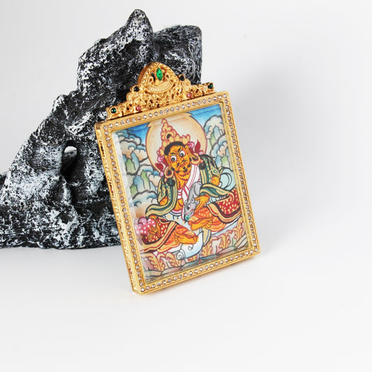 Front view of Yellow Jambhala mini thangka pendant highlighting the hand-painted deity figure, soft-toned landscape clouds, and crystal-trimmed gold-tone titanium steel pendant frame