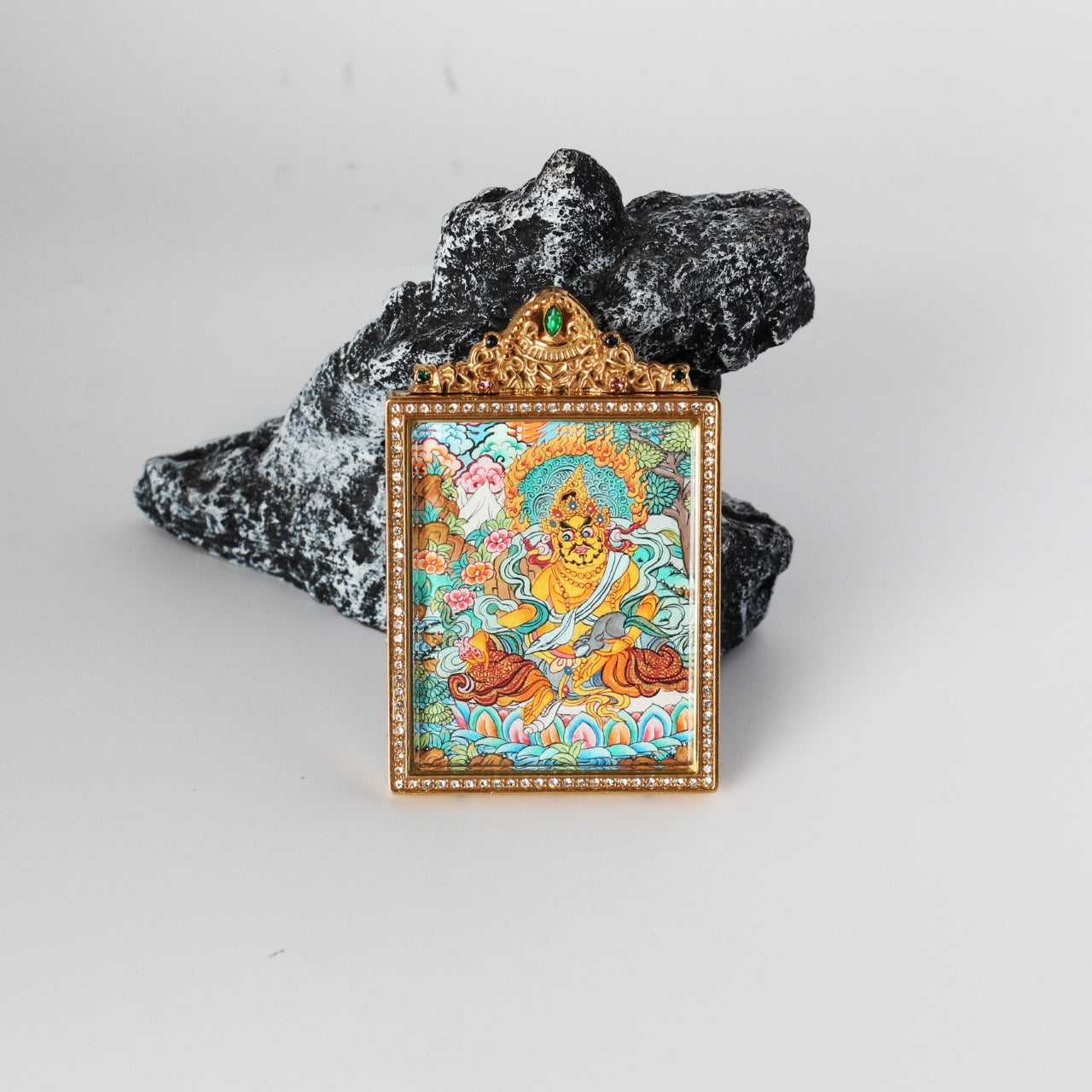 Front view of Yellow Jambhala mini thangka pendant, hand-painted with mineral pigments, rich gold-toned palette, enclosed in a double-sided jewelry-grade titanium steel case with detailed ornamentation
