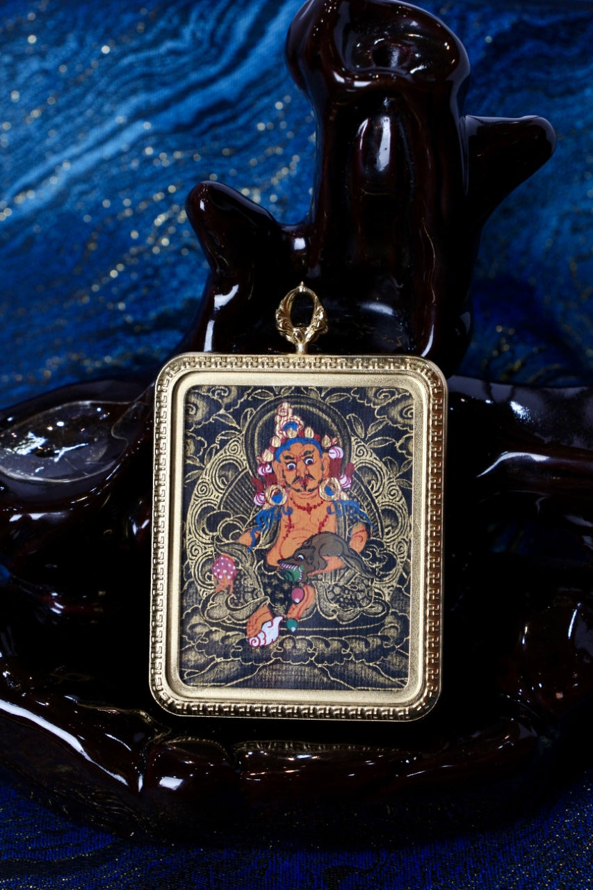 Front view of Yellow Jambhala mini thangka pendant in Nepalese black-gold style, hand-painted artwork set in a gold-tone titanium steel protective case