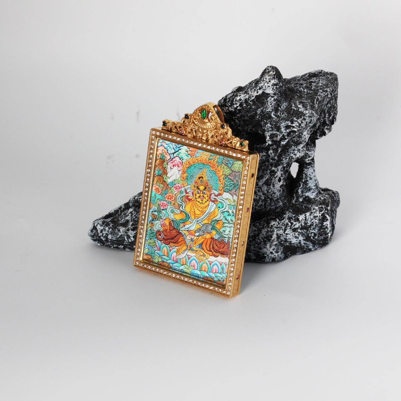 Side detail of Yellow Jambhala mini thangka pendant highlighting the double-sided construction, metal edge finishing, and refined hand-painted thangka craftsmanship