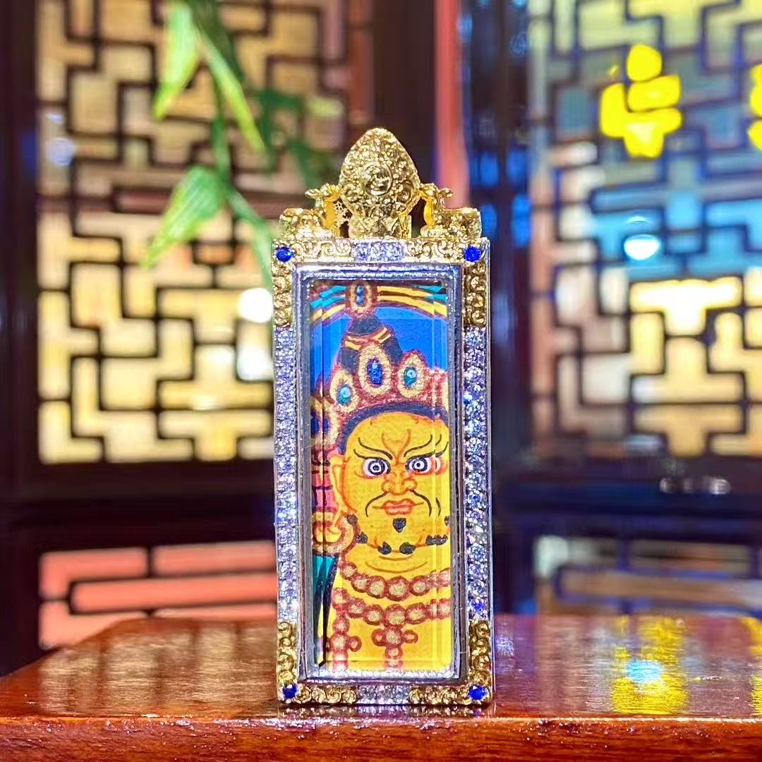 Hand-painted Yellow Jambhala mini Thangka pendant in a vertical rectangular copper Gau box, symbolizing protection and right wealth