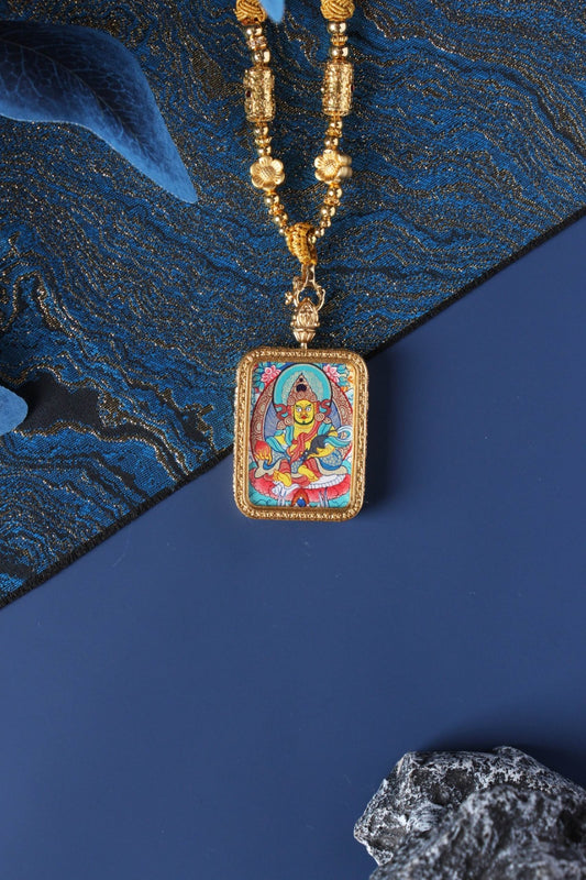 Hand-painted Yellow Jambhala mini thangka pendant displayed with gold-tone beaded necklace, rectangular double-sided titanium steel case, vivid mineral pigment artwork