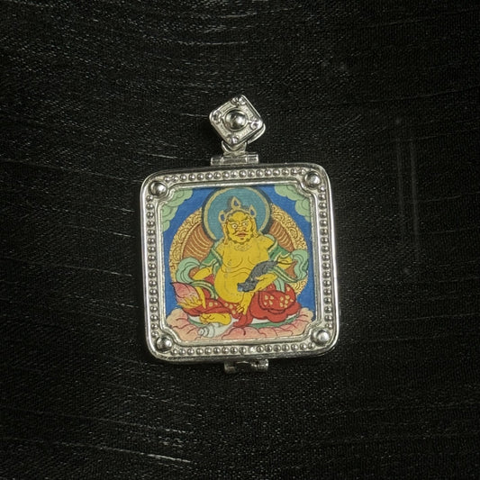 Close-up of Yellow Jambhala hand-painted mini thangka, blue background and lotus base, square 925 silver electroplated frame with beaded edging and corner studs