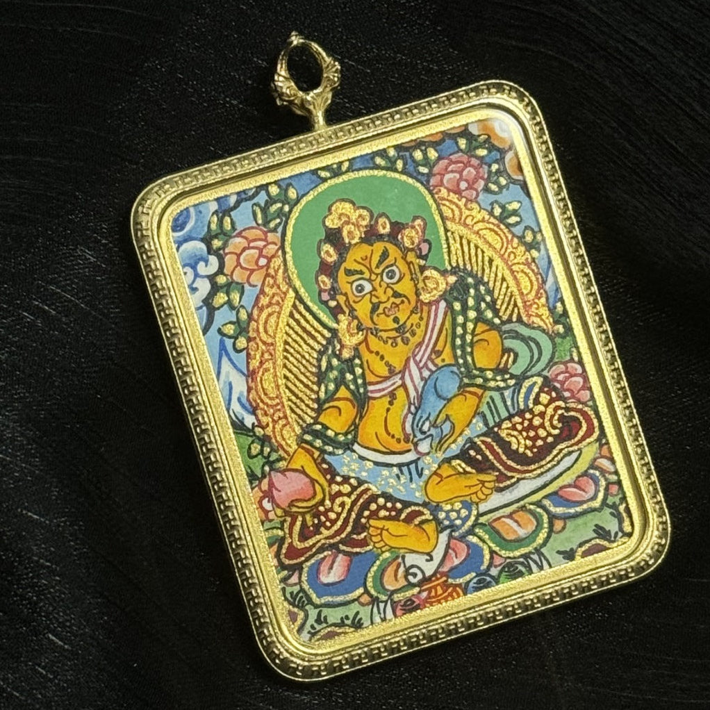 Close-up detail of Yellow Jambhala thangka pendant showing the wish-fulfilling jewel, treasure-spitting mongoose, and traditional Vajrayana iconography