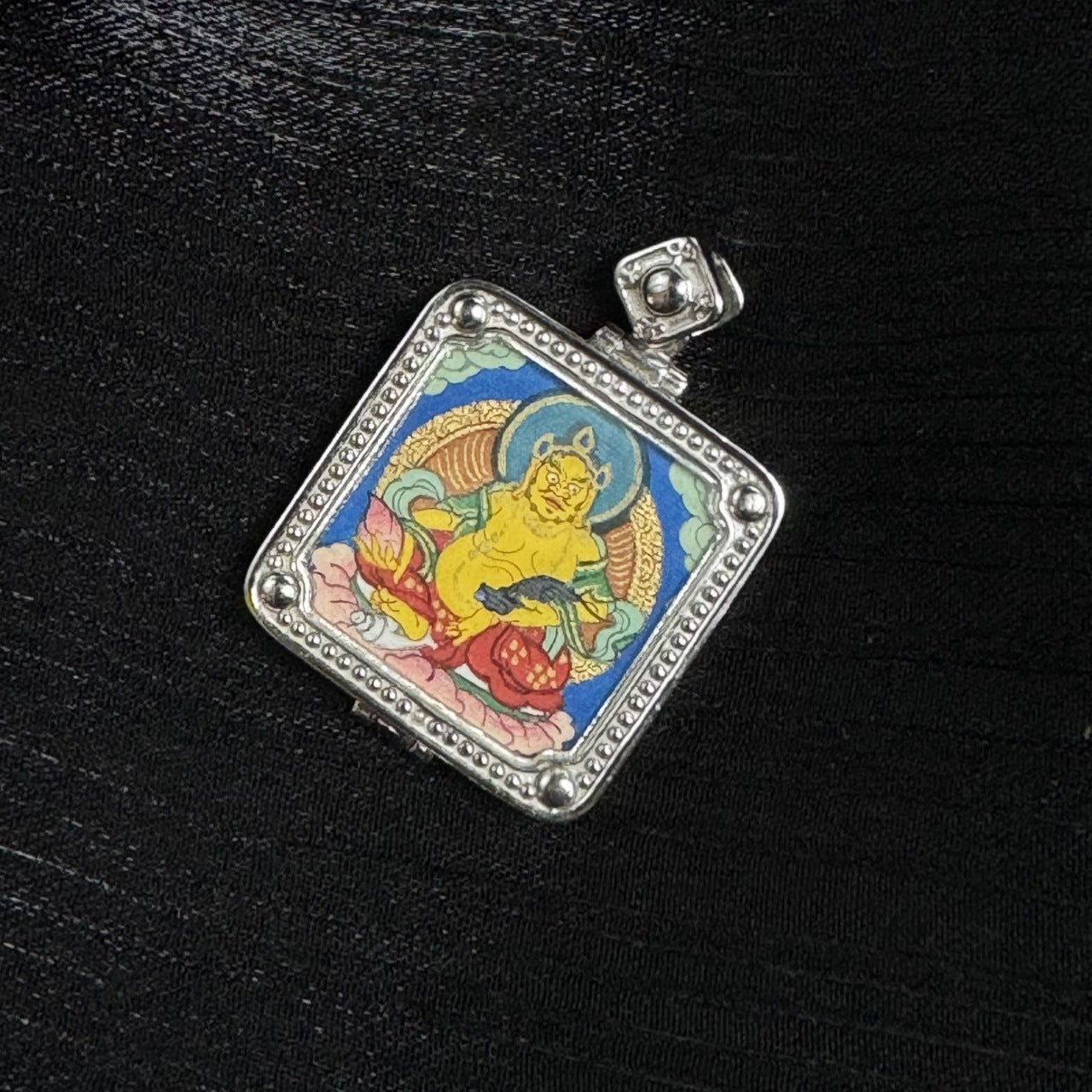 Square gawu-style pendant close-up featuring Yellow Jambhala, 925 silver electroplated case with dotted border, halo and lotus details, compact portable format