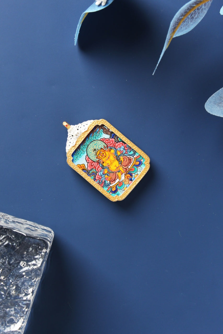 Yellow Jambhala Tibetan mini thangka pendant from Rebgong, detailed hand-painted wealth deity with mineral pigments and silver-plated frame