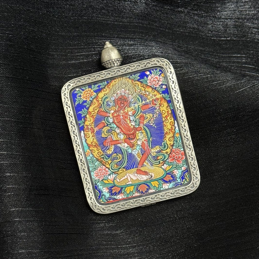 Angled view of Yeshe Tsogyal mini thangka pendant, Rebgong Tibetan painting, vibrant mineral pigments, silver frame, heirloom-quality craftsmanship