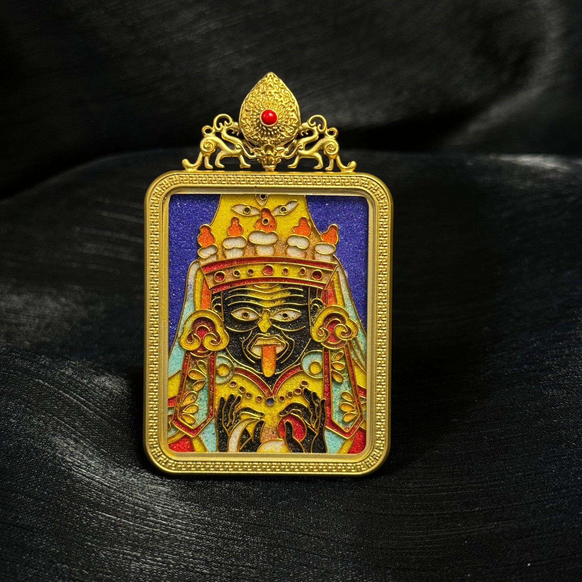 Front view of Zaki Lhamo mini thangka pendant featuring cloisonné enamel deity artwork, gold-plated copper frame, and traditional Tibetan decorative crown detail.