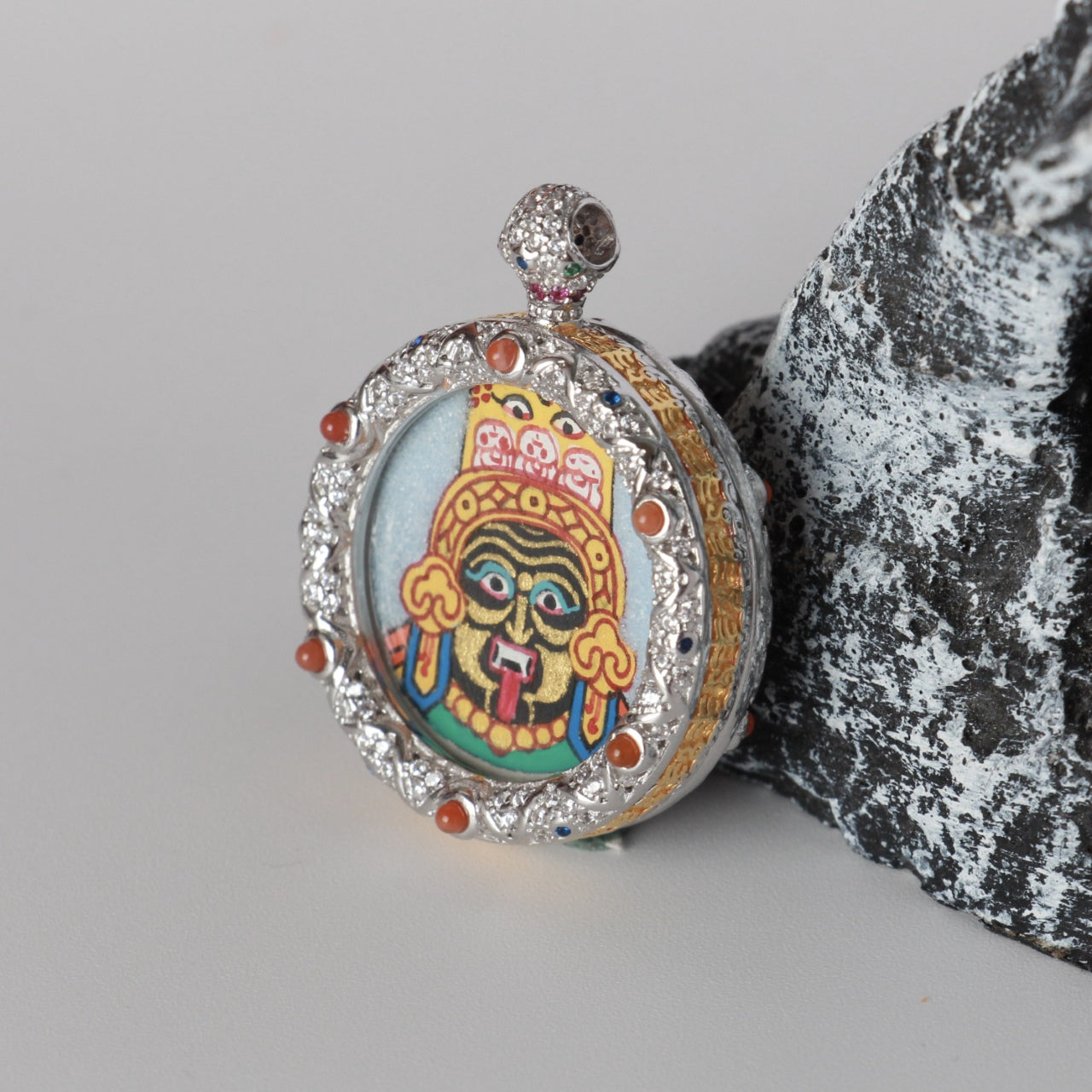 Angled view of the Zaki Lhamo mini thangka pendant highlighting the thickness of the copper case, layered metal texture, and mineral pigment surface.