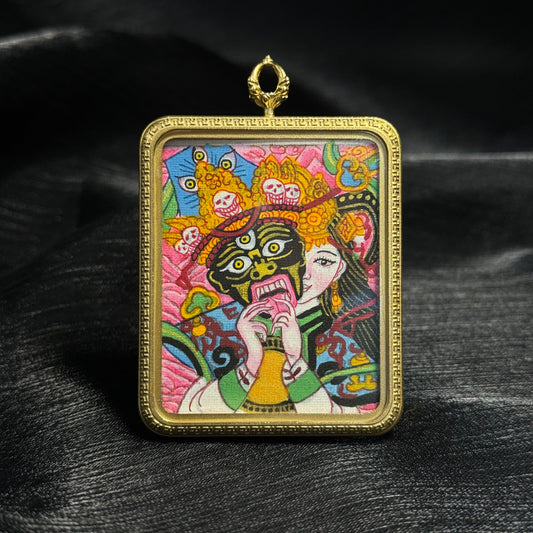 Front view of Zaki Lhamo mini thangka pendant featuring vivid hand-painted Nepalese color thangka artwork with expressive deity face and gold pendant frame.