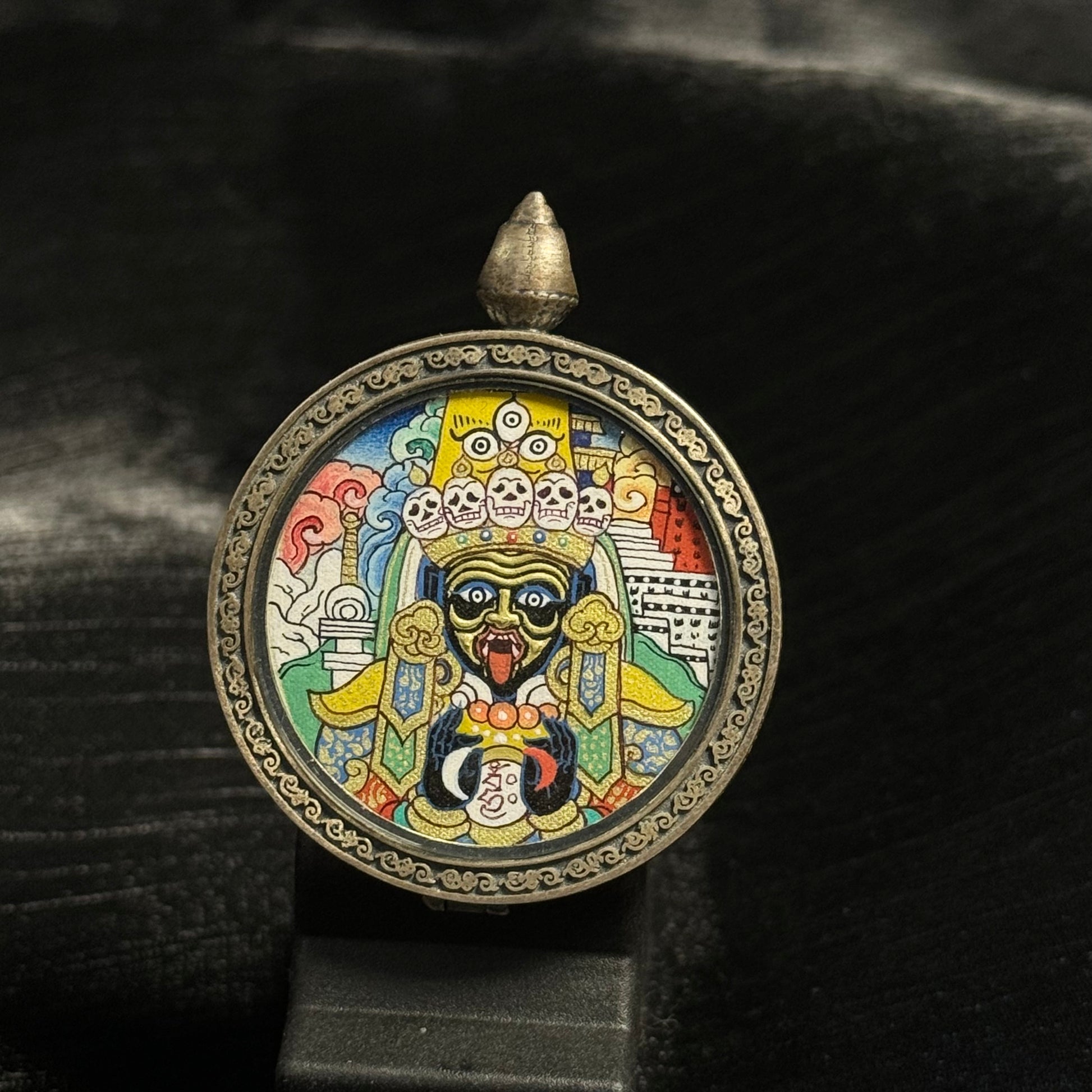Front view of round Zaki Lhamo mini thangka pendant featuring a hand-painted Tibetan protective goddess with Potala Palace background, created with mineral pigments and gold powder in the Rebgong thangka tradition.