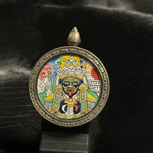 Front view of round Zaki Lhamo mini thangka pendant featuring a hand-painted Tibetan protective goddess with Potala Palace background, created with mineral pigments and gold powder in the Rebgong thangka tradition.