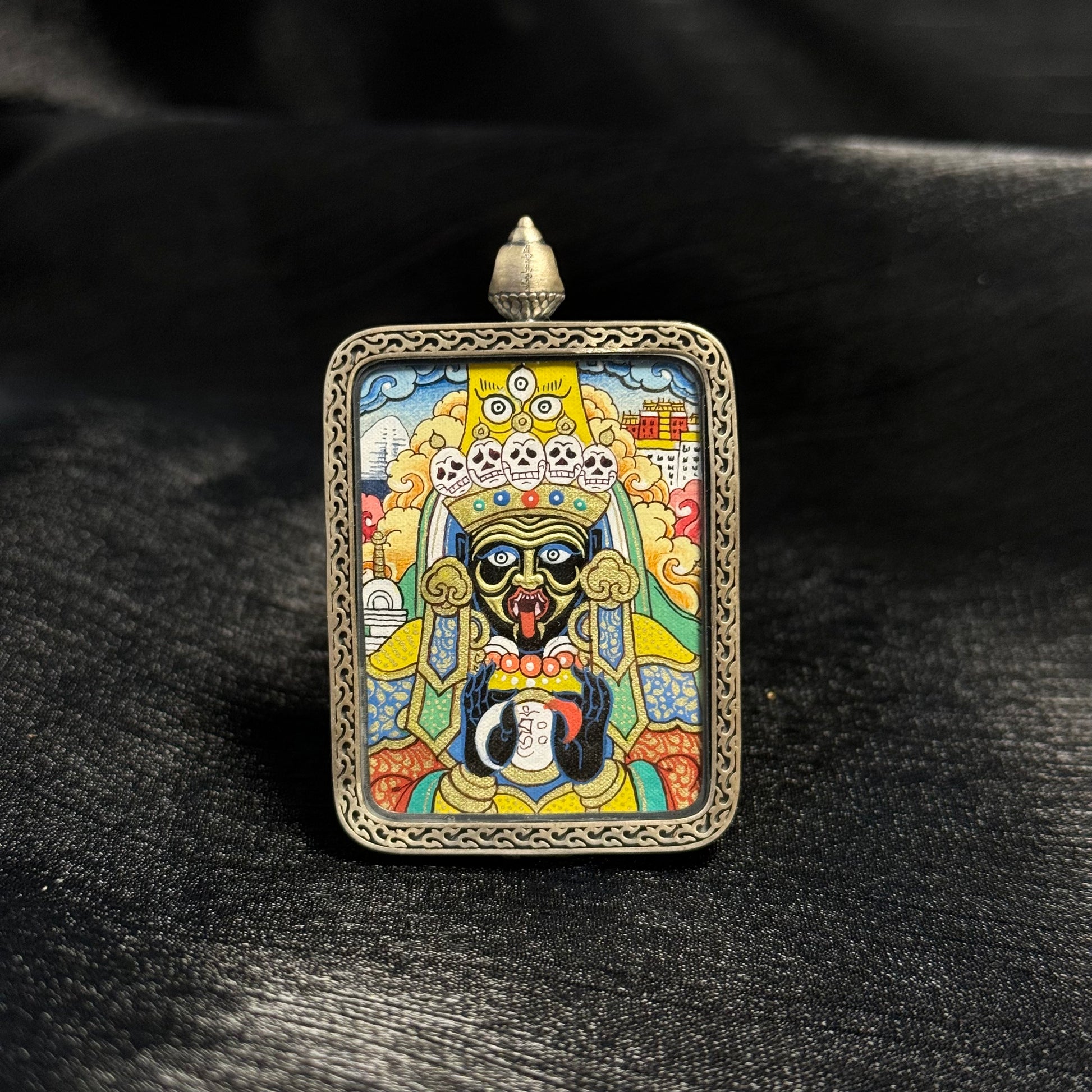 Front view of Zaki Lhamo Potala Palace form mini thangka pendant, hand-painted with mineral pigments and gold powder in the Rebgong Tibetan thangka tradition, set inside a decorative silver pendant frame.