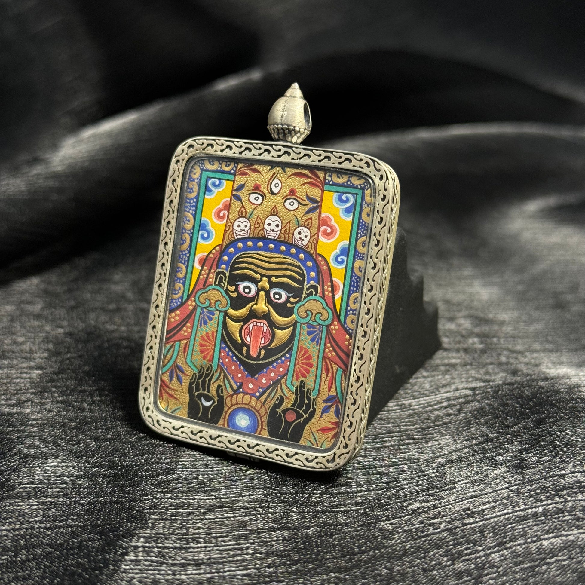 Detailed view of Zaki Lhamo Rebgong gold relief miniature thangka pendant showing dimensional gold pigment texture and decorative 925 silver pendant frame