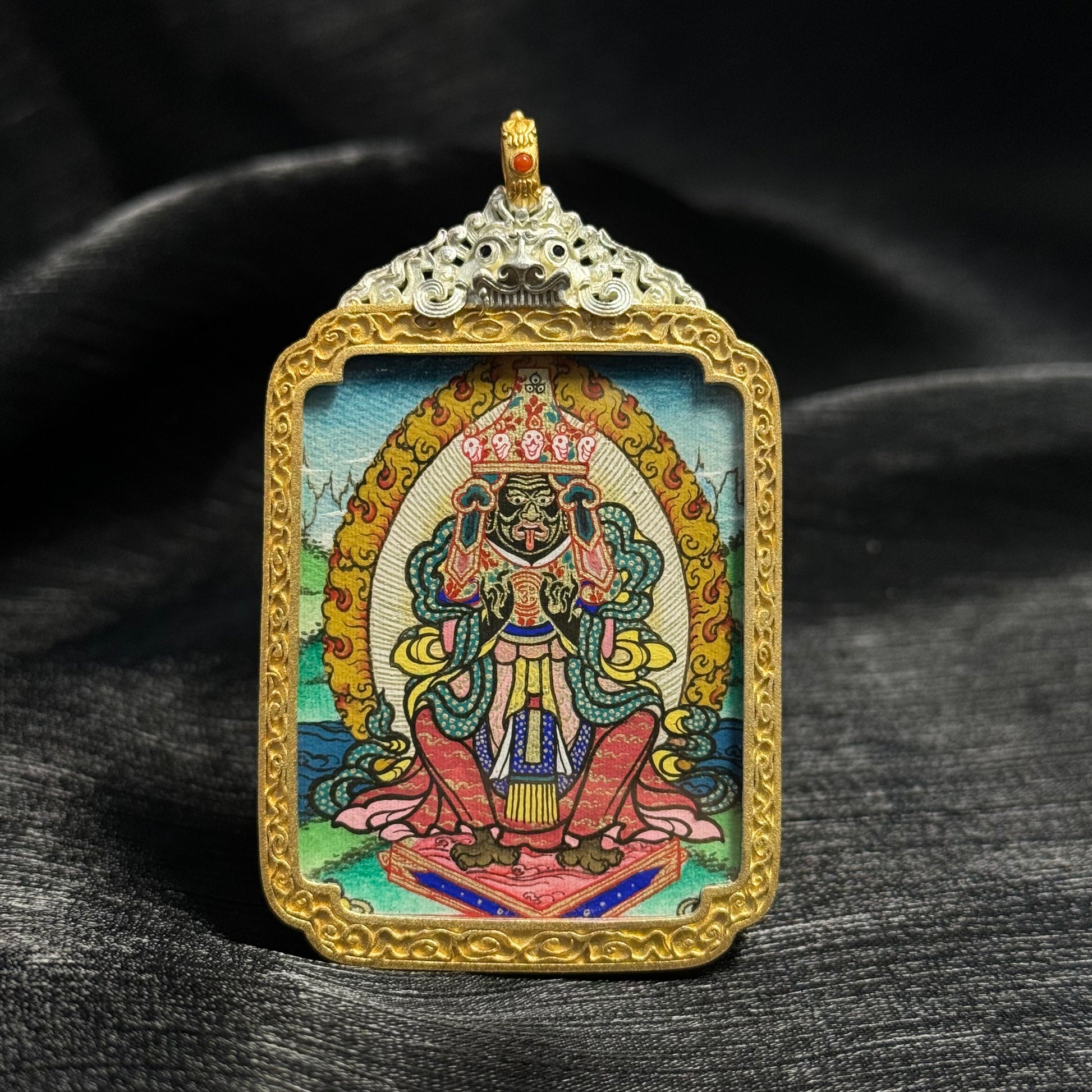 Front view of Zaki Lhamo mini thangka pendant featuring hand-painted Rebgong mineral pigment artwork, detailed deity figure, and ornate gold decorative frame.