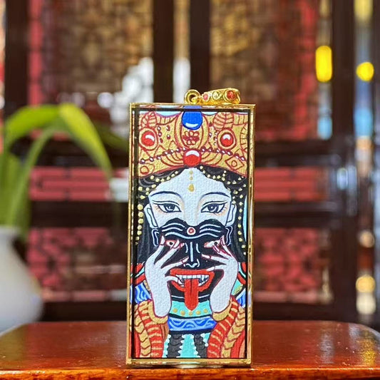 Front view of a hand-painted Zaki Lhamo thangka depicting the Tibetan female guardian deity, set in an 18K gold gau box with sapphire crystal protection