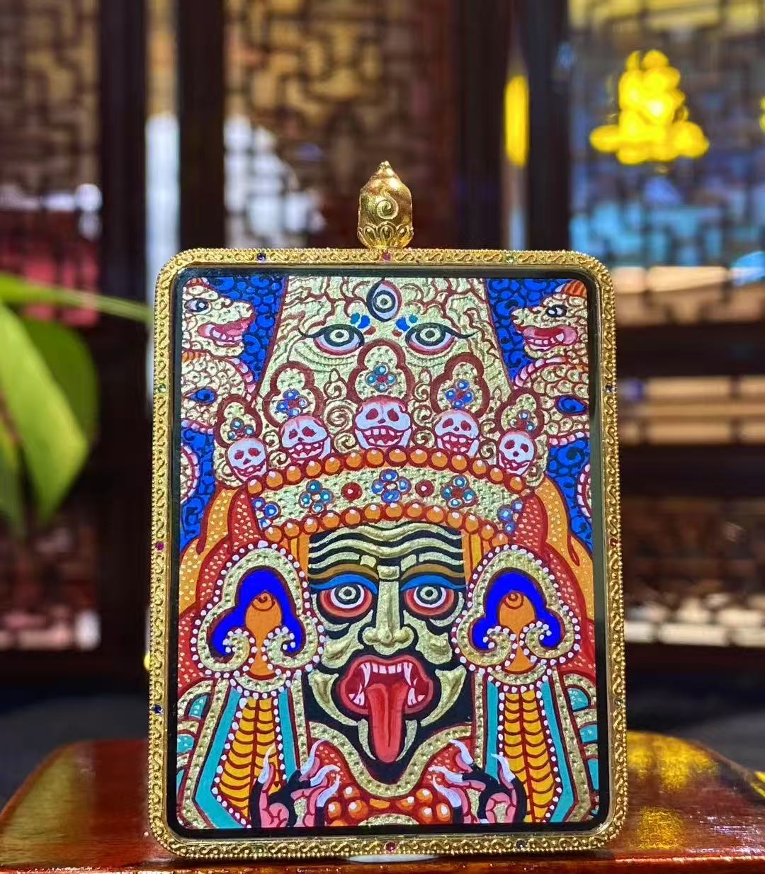 Back view of a double-sided Zaki Lhamo Thangka pendant, hand-painted with raised 18K gold detailing, featuring skull crown, three eyes, and symbolic dragons in Rebgong style.
