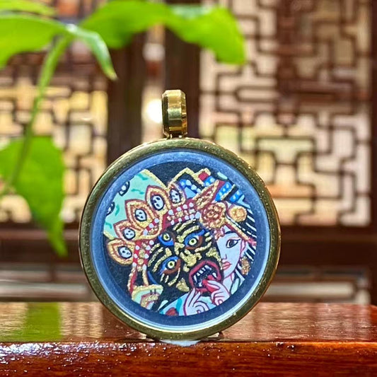 Front view of a hand-painted Zaki Lhamo thangka pendant depicting the Tibetan female wealth guardian, finished with gold detailing and set in a titanium steel gau box