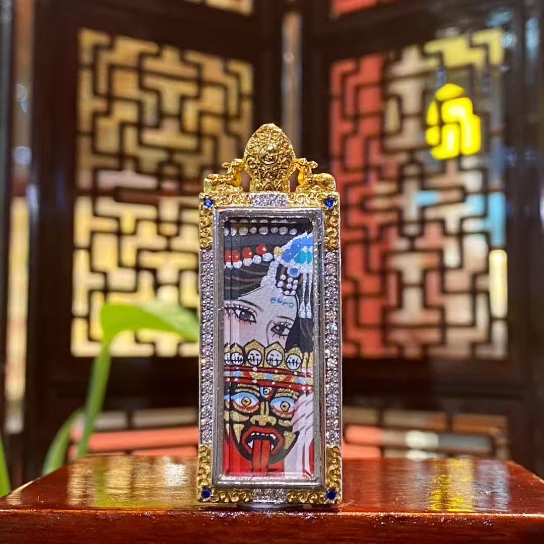 Front view of a hand-painted Zaki Lhamo thangka pendant depicting the fierce Tibetan guardian goddess, set in a traditional copper gau box