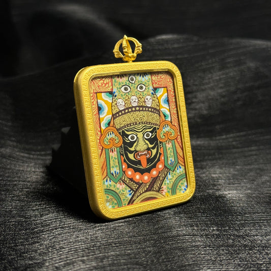 Angled view of Zaki Lhamo Tibetan mini thangka pendant showing detailed mineral pigment painting, flowing linework, and traditional Rebgong thangka craftsmanship inside a gold pendant frame.