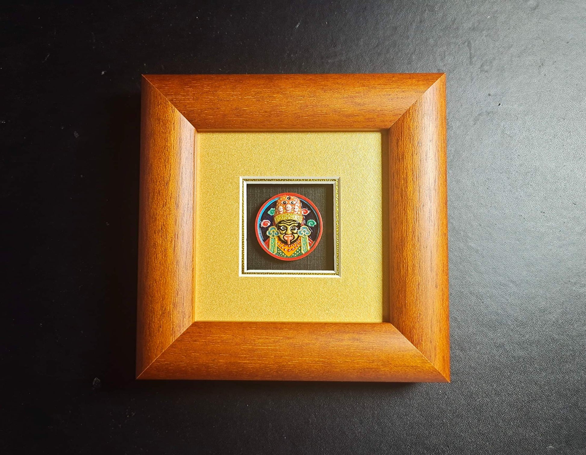 Front view of Zaki Ram hand-painted tsa-tsa thangka table display framed in Indonesian cypress wood with mineral pigment painted protector goddess image