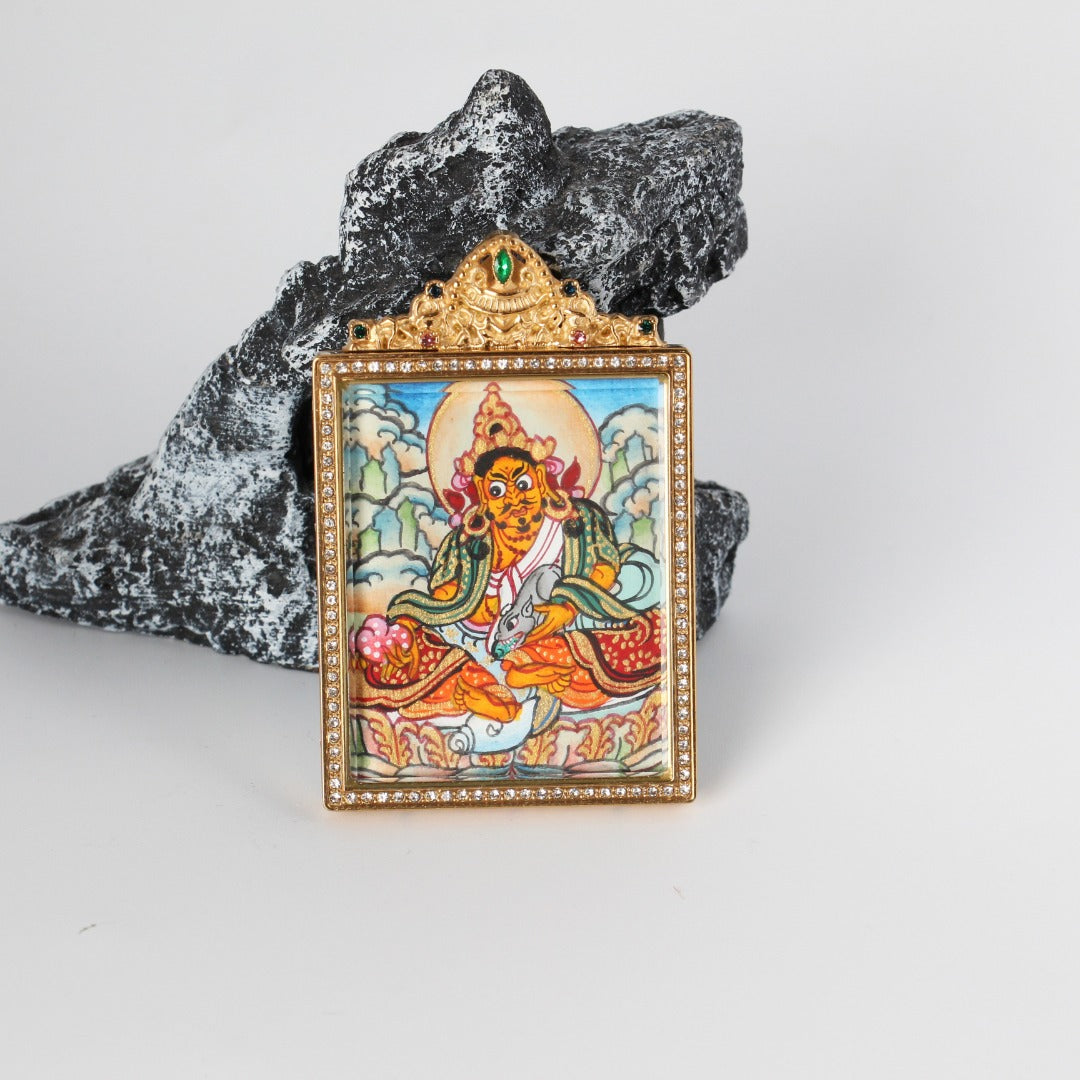 Side-detail view of Yellow Jambhala mini thangka pendant showing the raised titanium steel housing, crystal-style bezel border, and structured double-sided pendant profile