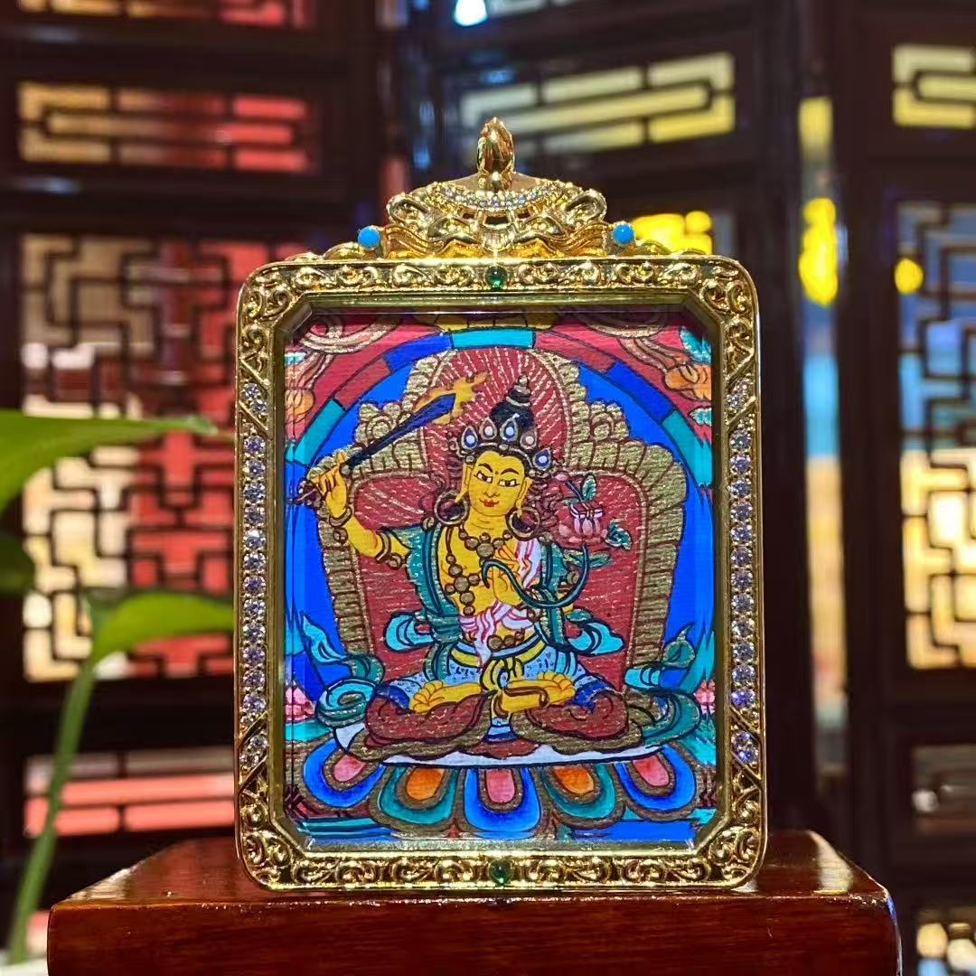 Front view of a double-sided Manjushri Bodhisattva mini thangka pendant, hand-painted and set in a gold-plated copper Gau box