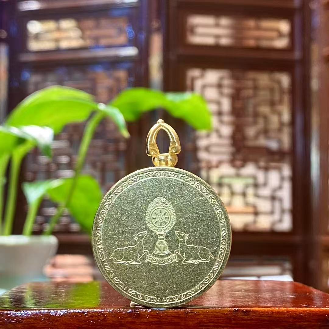 Back view of a Manjushri Bodhisattva mini thangka pendant featuring a Dharma Wheel with deer motif engraved on a titanium steel Gau box