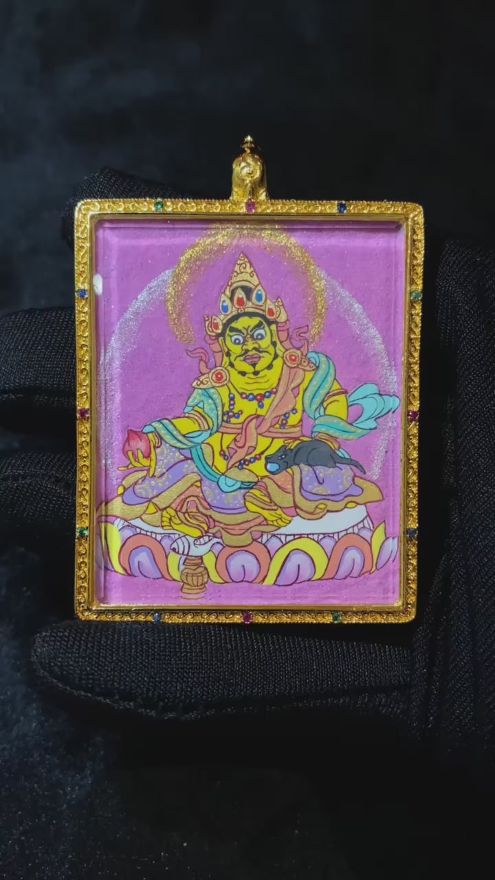 Close-up video of a hand-painted Yellow Jambhala mini Thangka pendant in a traditional copper Gau box, highlighting protective symbolism and craftsmanship