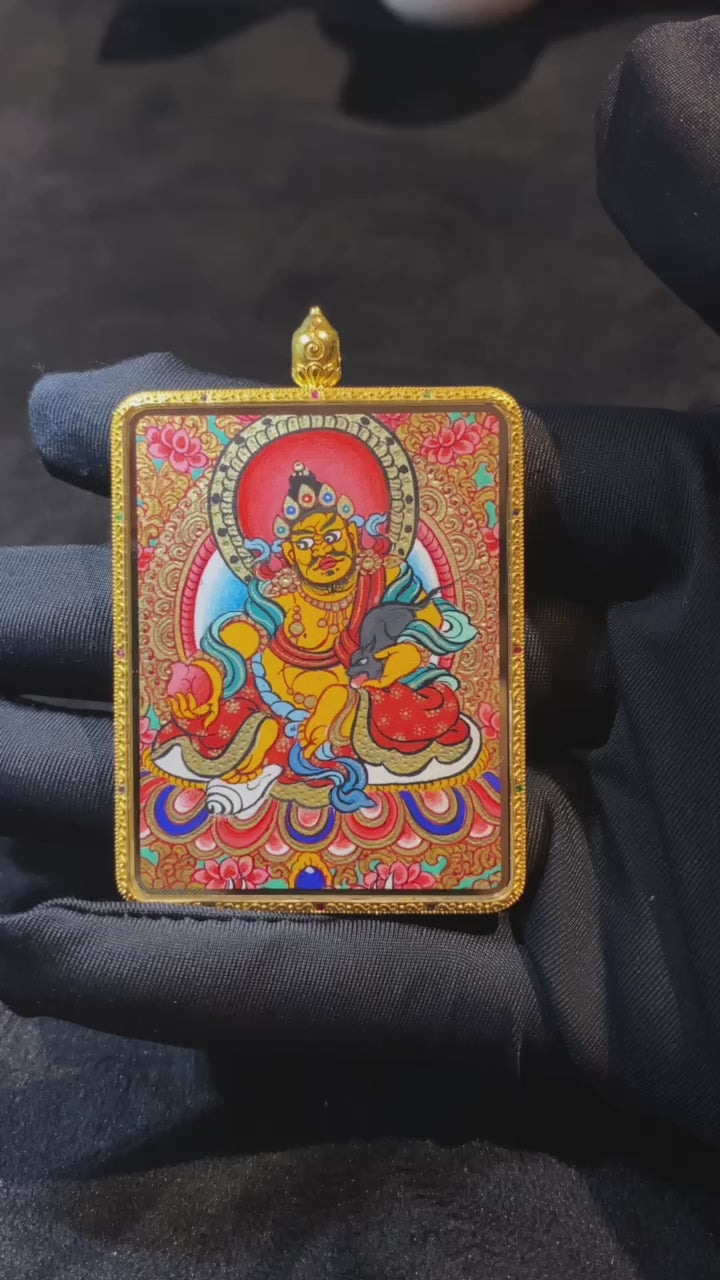 Close-up video of a large double-sided Tibetan Thangka pendant featuring Zaki Lhamo and Yellow Jambhala, fully hand-painted in 18K gold with full-detail Rebgong craftsmanship, set in a sapphire crystal Gawu box