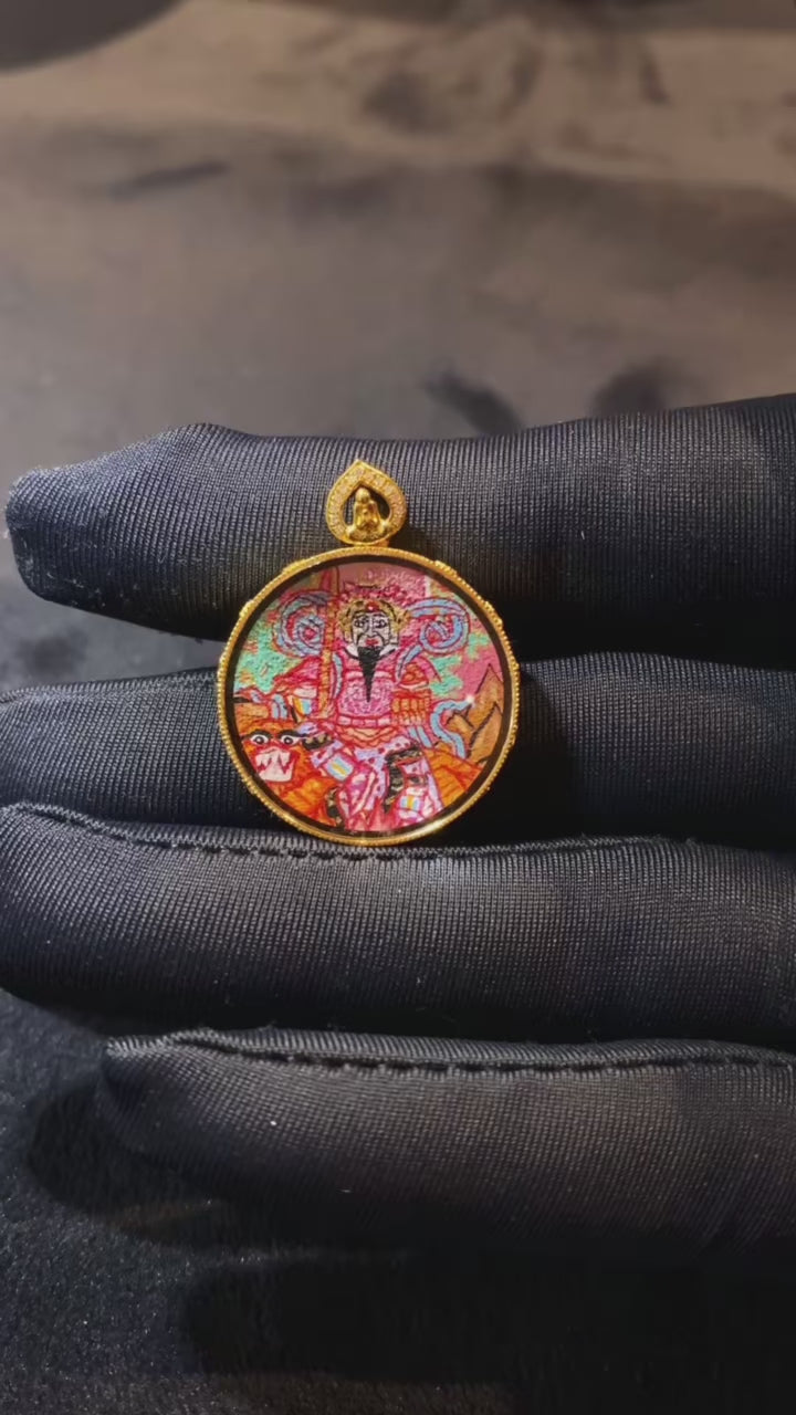 Close-up video of a Zhao Gongming and lotus Taoist Thangka pendant, double-sided and hand-painted in 18K gold, crafted in Rebgong style and set in a sapphire-lens Gawu box