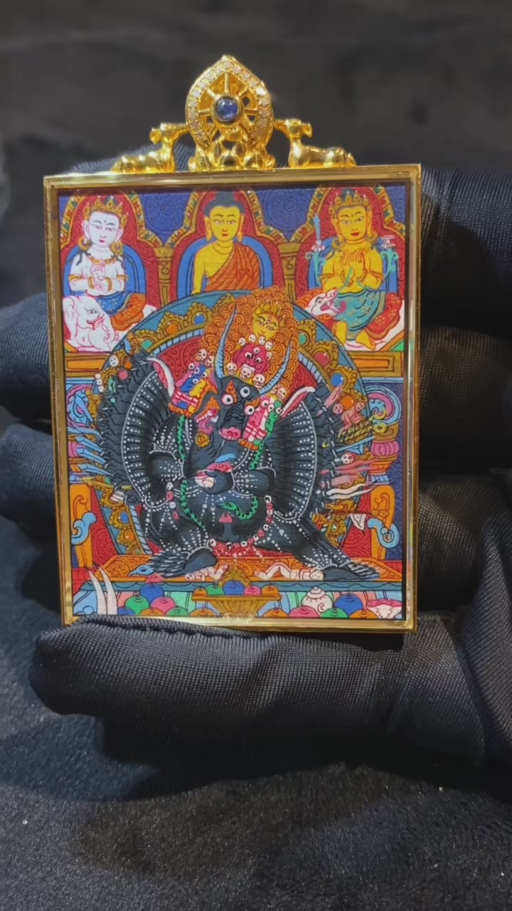 Close-up video of 18K gold double-sided hand-painted Yamantaka and Five Jambhalas thangka pendant, showing Rebgong master-level details, Gau box, and sapphire crystal