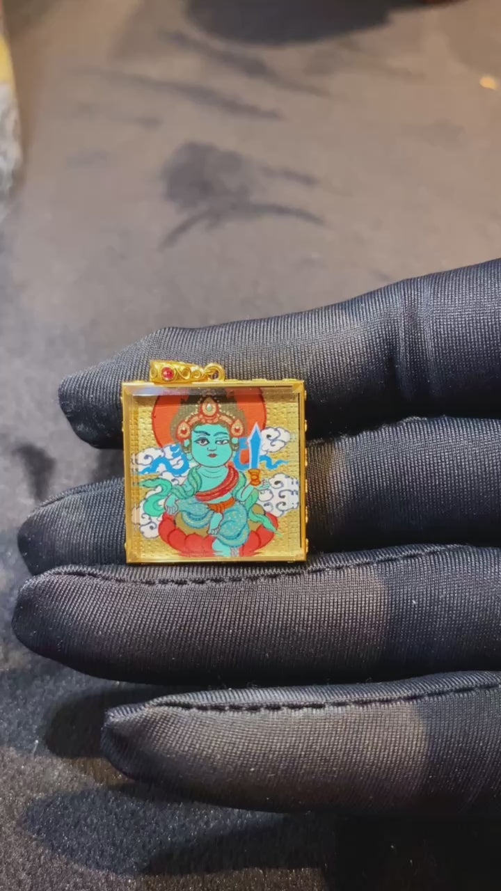 Video showcasing a double-sided hand-painted Gau Thangka pendant with Green Tara on the front and Acala Vidyaraja on the back, crafted in an 18K gold case with sapphire crystal protection