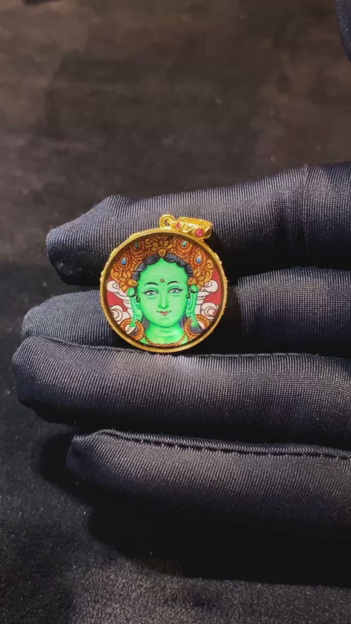 Product video showcasing a round double-sided Green Tara and Om Mani Padme Hum Thangka pendant, hand-painted with 18K gold in Rebgong tradition and set in a sapphire crystal Gau box.
