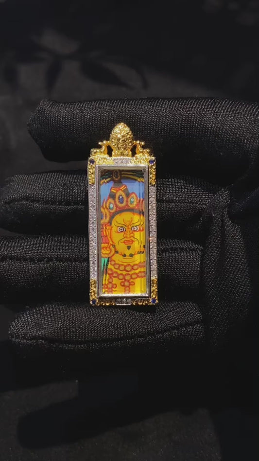 Close-up video of a hand-painted Yellow Jambhala mini Thangka pendant in a vertical copper Gau box, highlighting its protective symbolism and craftsmanship